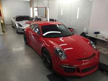 Porsche and Corvette in the garage waiting for XPEL ULTIMATE installations